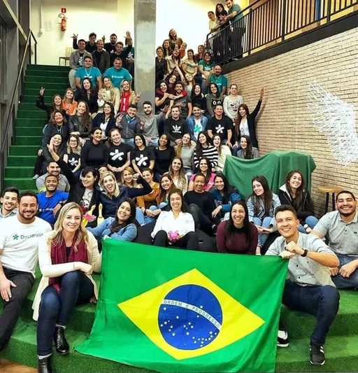 Raphael Corrêa com sua equipe de inside sales segurando a bandeira do Brasil